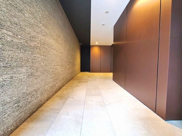 【エントランスホール】石貼りの壁が印象的なエントランスホール